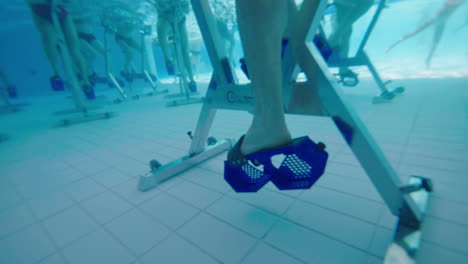 Close-underwater-shot-of-a-man-pedaling-on-an-aqua-bike-in-a-swimming-pool